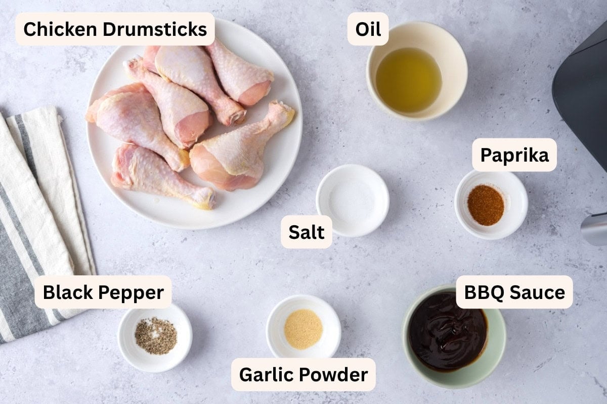 ingredients to make bbq chicken drumsticks on counter  with labels.