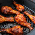 crispy bbq chicken drumsticks in the air fryer basket.
