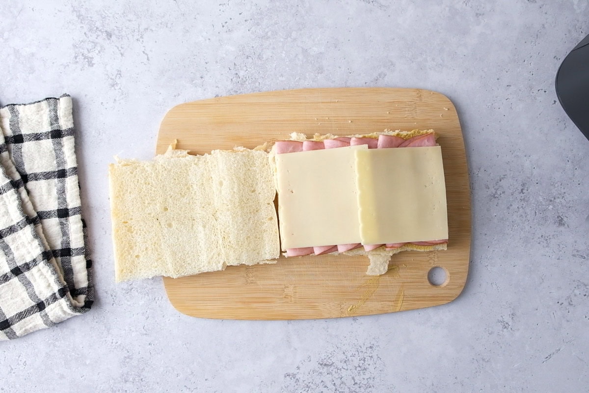 slices of swiss cheese on ham on slider buns.