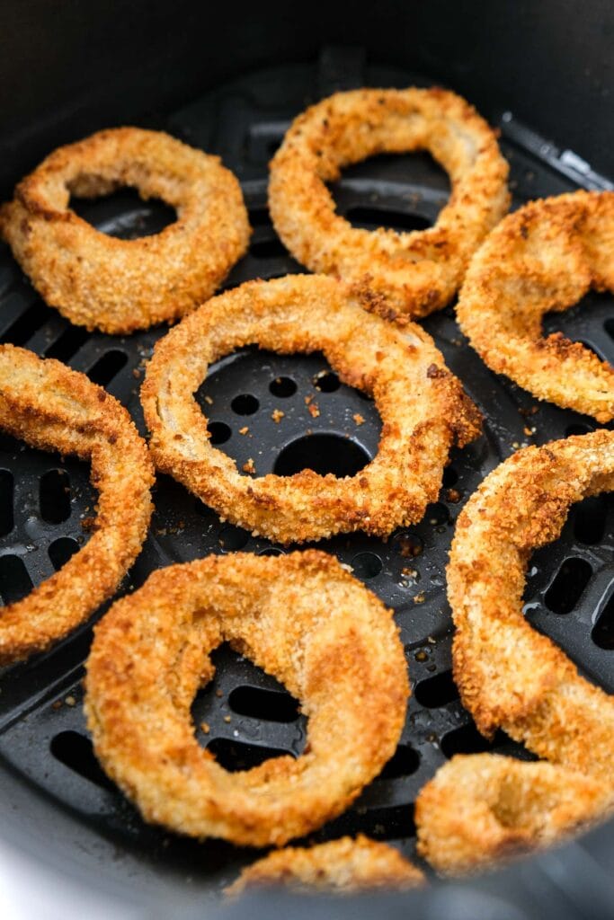 crispy onion rings in air fryer basket.