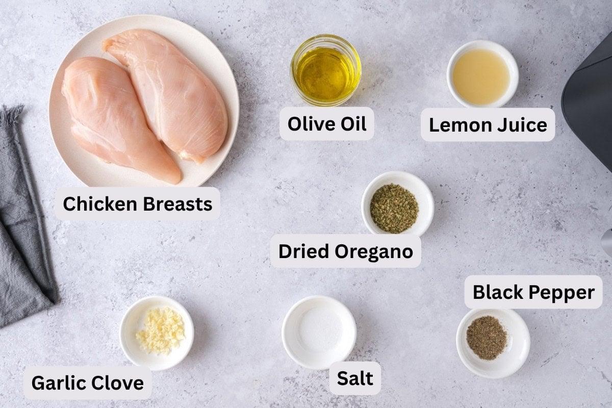 ingredients to make greek chicken souvlaki skewers in bowls with labels on counter.
