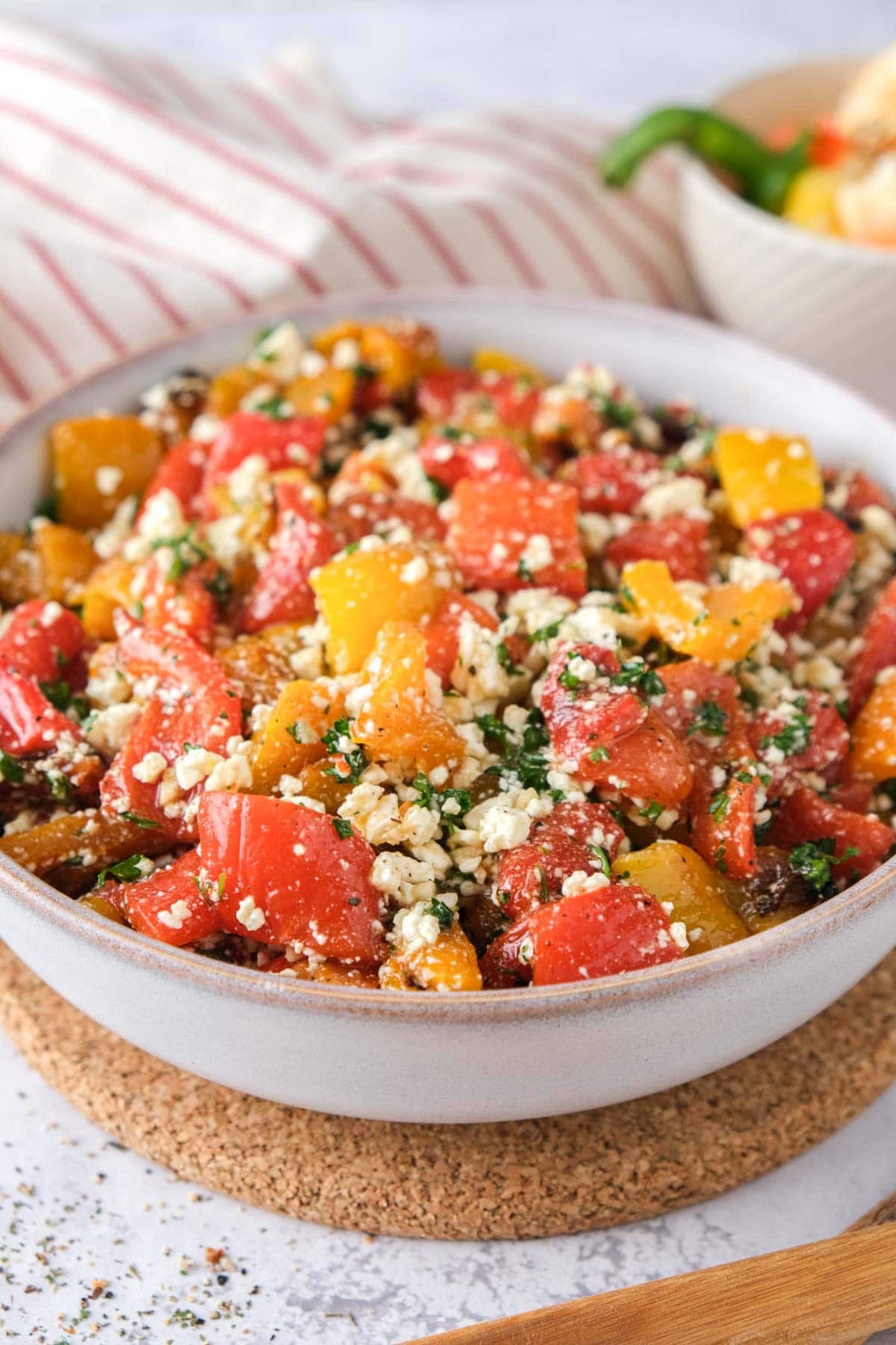 roasted bell pepper salad with feta and parsley in bowl.