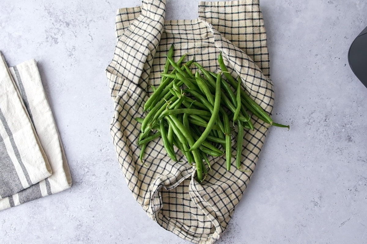 green beans in drying cloth on counter.