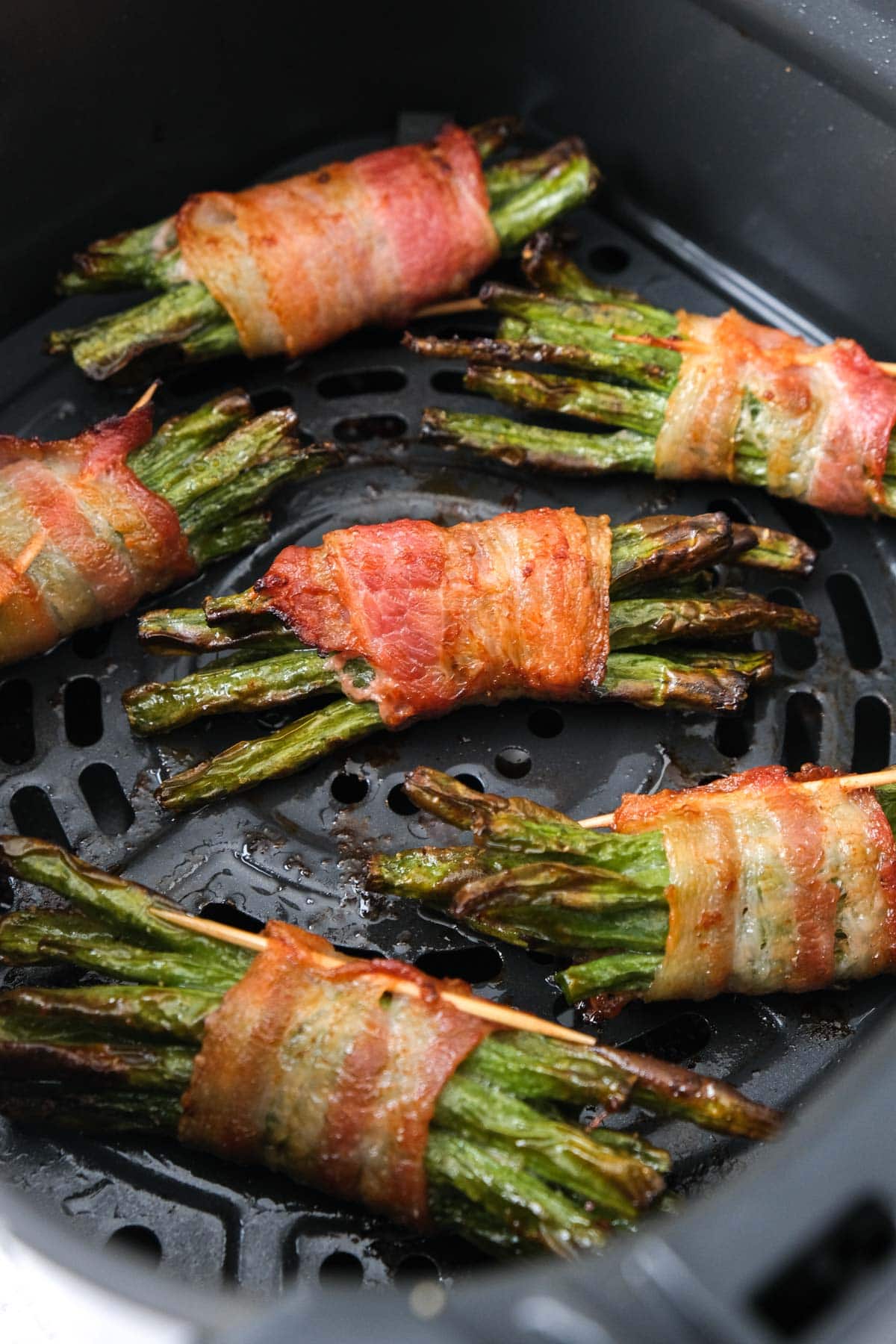 bacon wrapped green beans in air fryer basket.