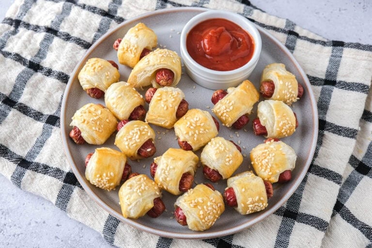homemade pigs in a blanket with ketchup on plate.