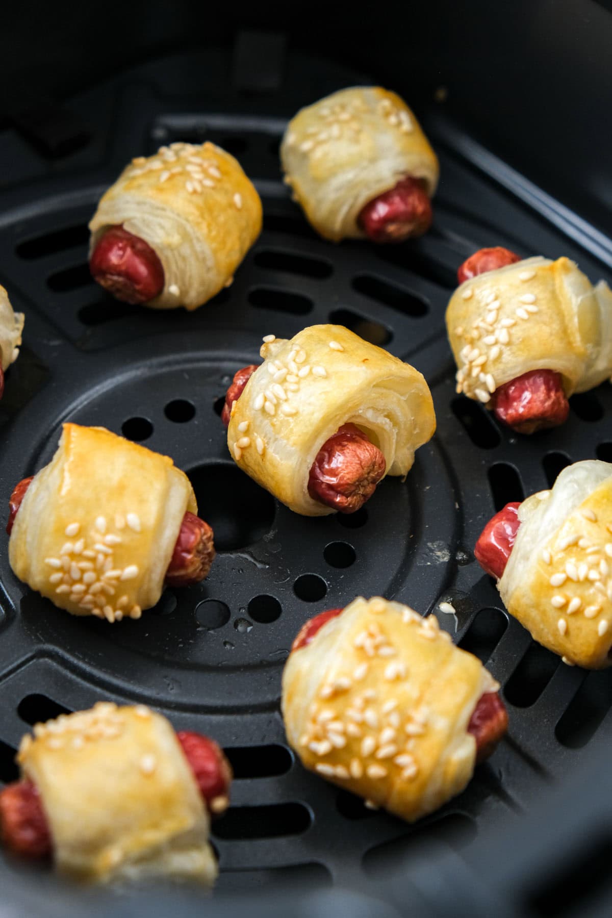 homemade pigs in blankets in air fryer basket.