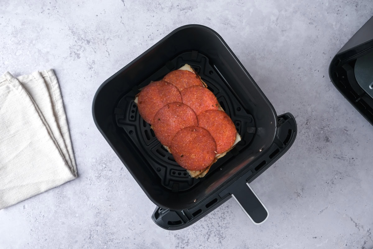 open face pizza sliders in black air fryer basket.