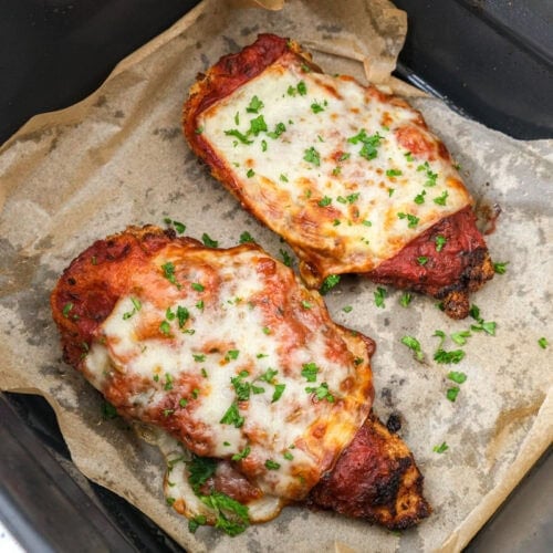 cooked chicken parmesan in air fryer basket.