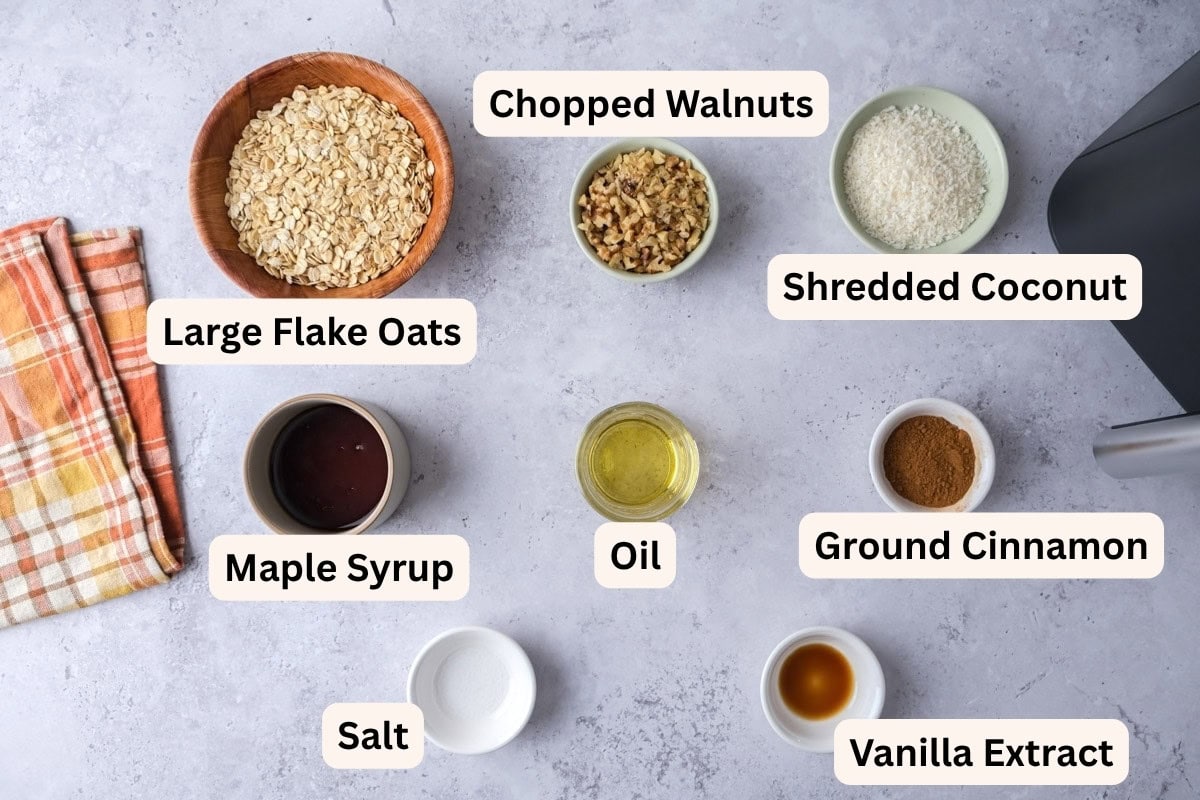 ingredients to make air fryer granola on counter in bowls with labels.