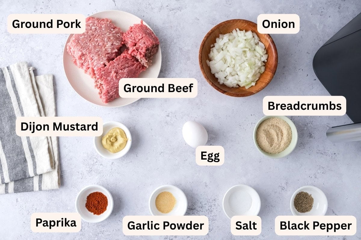 ingredients to make mini meatloaves on counter in bowls with labels.